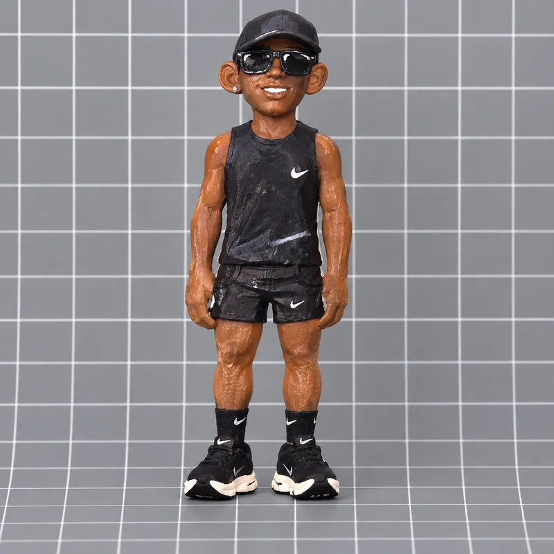Miniatura humana personalizada com boné preto, óculos, camiseta esportiva e tênis.